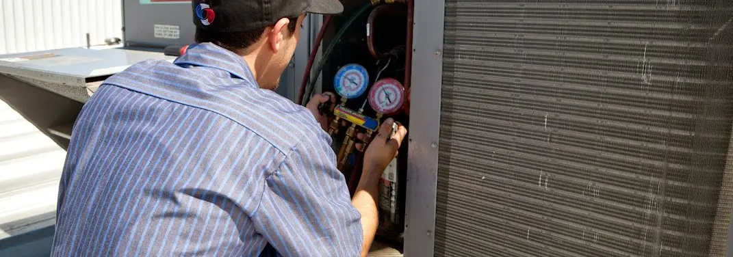 HVAC technician servicing a condenser unit in Upper Grand Lagoon